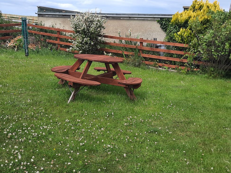 A garden with a picnic table and grass at 4 Cliff Cottages