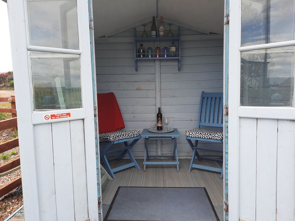A garden shed with a shelf and seating at 4 Cliff Cottages