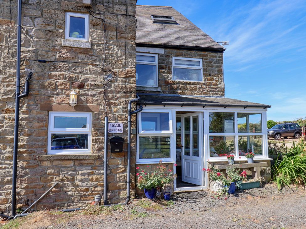 A stone house with a front door and planters at 4 Cliff Cottages Port Mulgrave near Staithes