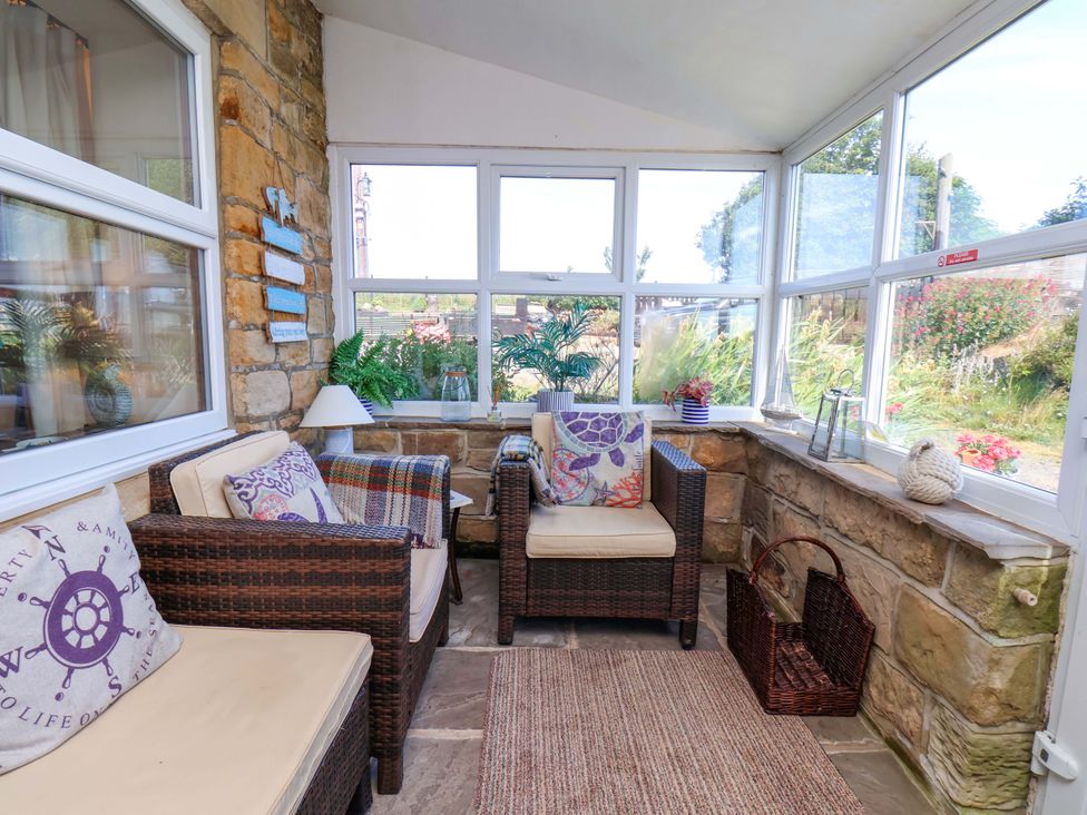 A conservatory with seating and plants at 4 Cliff Cottages Port Mulgrave near Staithes