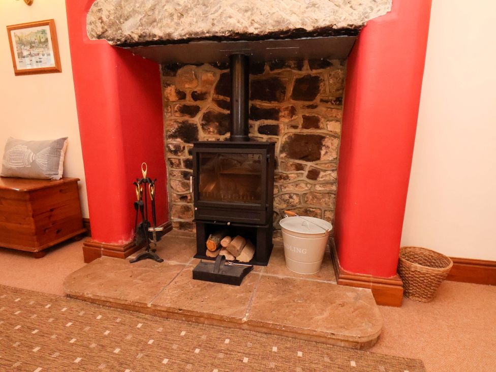 A living room with a wood stove and stone wall at 4 Cliff Cottages Port Mulgrave near Staithes