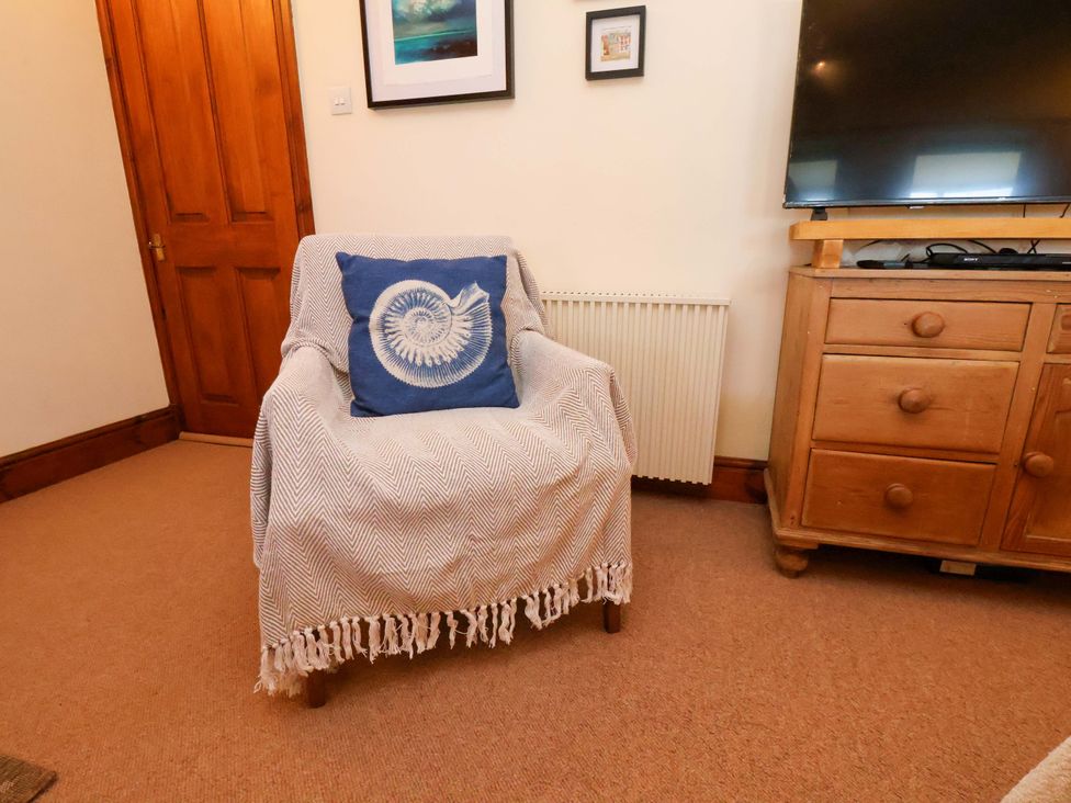 A living room with an armchair and television at 4 Cliff Cottages Port Mulgrave near Staithes