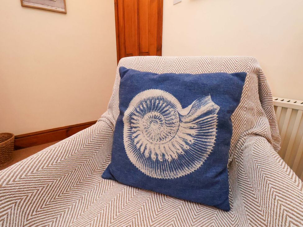 A cushion on a chair in a living room at 4 Cliff Cottages Port Mulgrave near Staithes