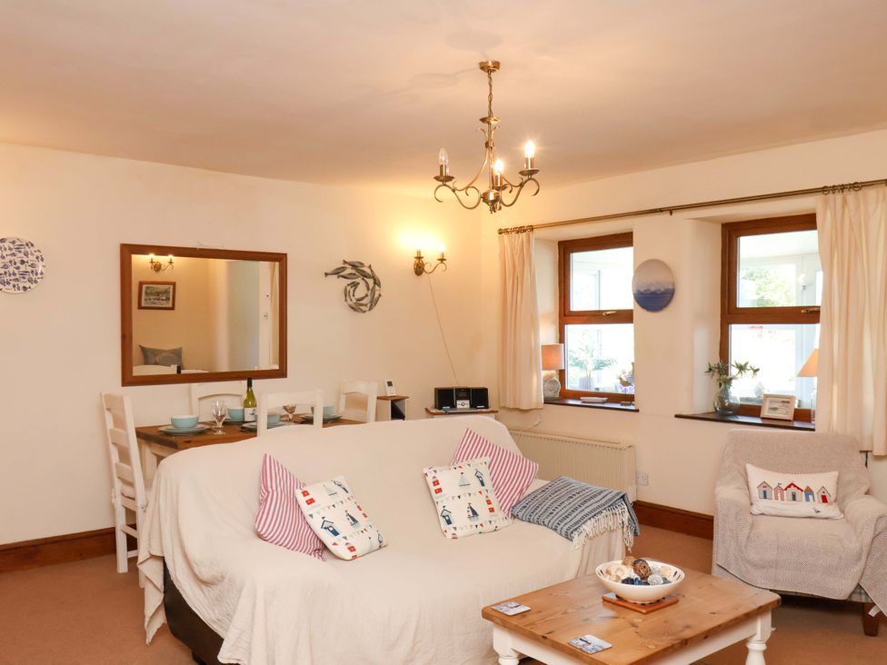 A living room with a sofa and dining area at 4 Cliff Cottages Port Mulgrave near Staithes