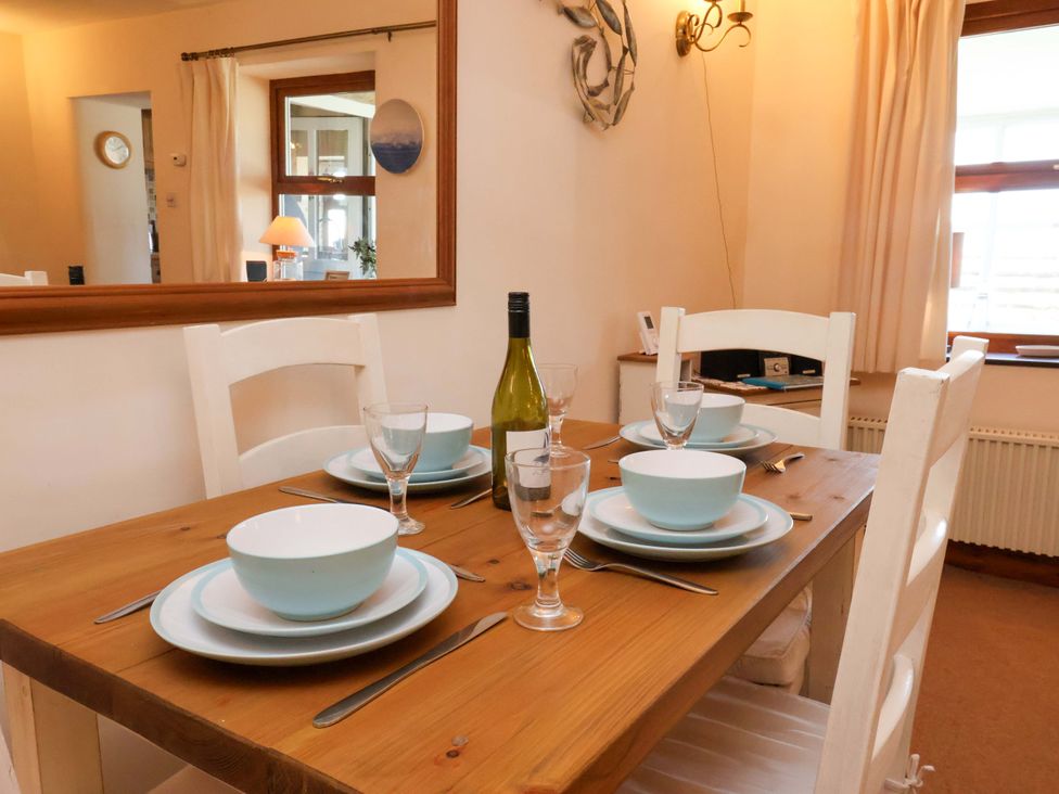 A dining room with table set for meal including wine at 4 Cliff Cottages in Port Mulgrave near Staithes