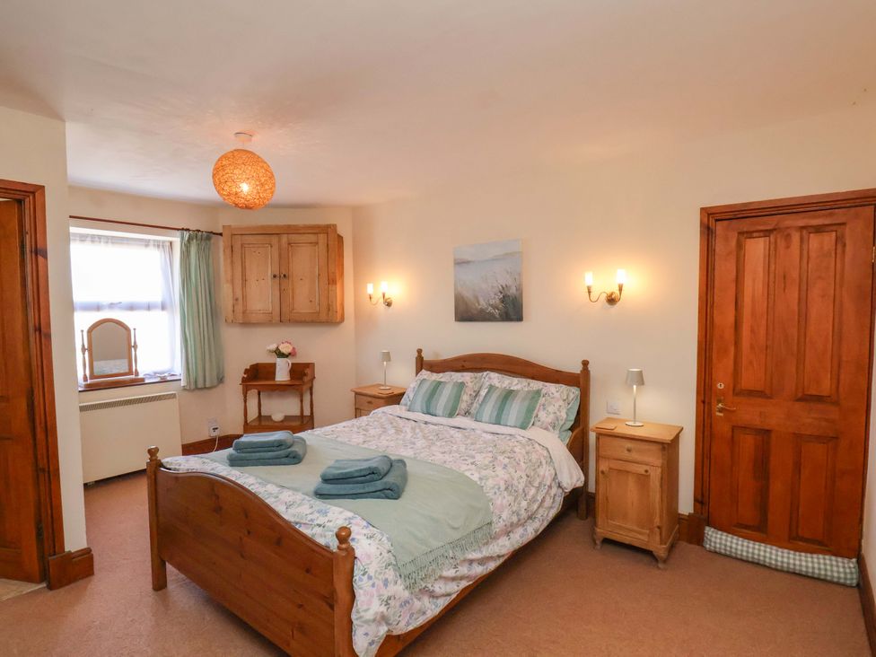 A bedroom with a bed and nightstands at 4 Cliff Cottages Port Mulgrave near Staithes