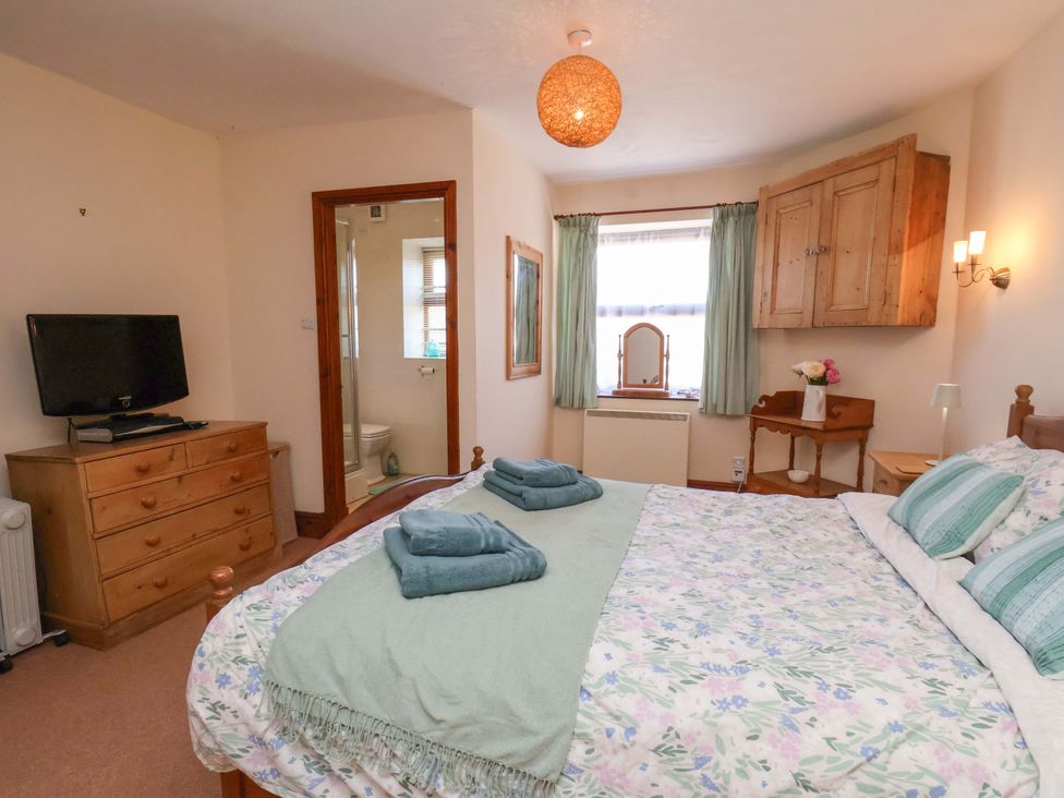 A bedroom with a bed and a tv at 4 Cliff Cottages Port Mulgrave near Staithes