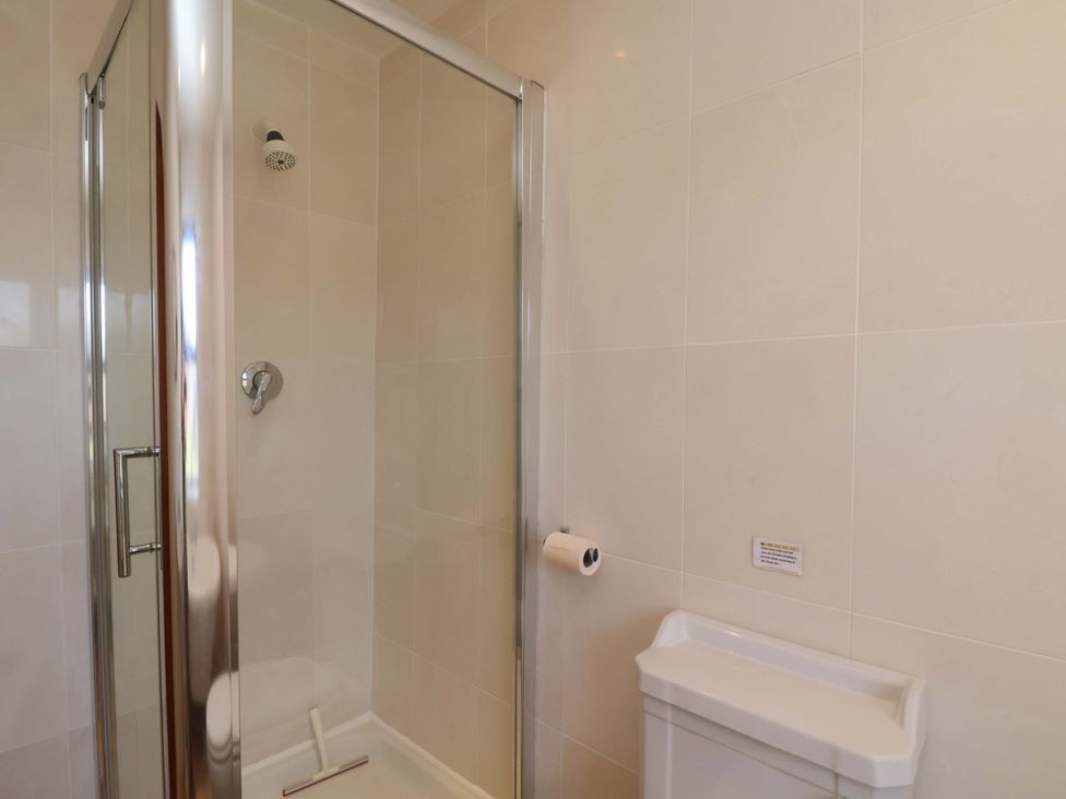 A shower with a glass enclosure and a soap dish in 4 Cliff Cottages Port Mulgrave near Staithes