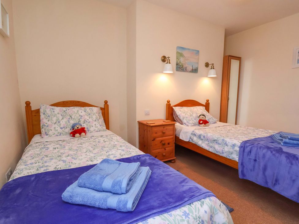 A bedroom with two beds and a bedside table at 4 Cliff Cottages in Port Mulgrave near Staithes