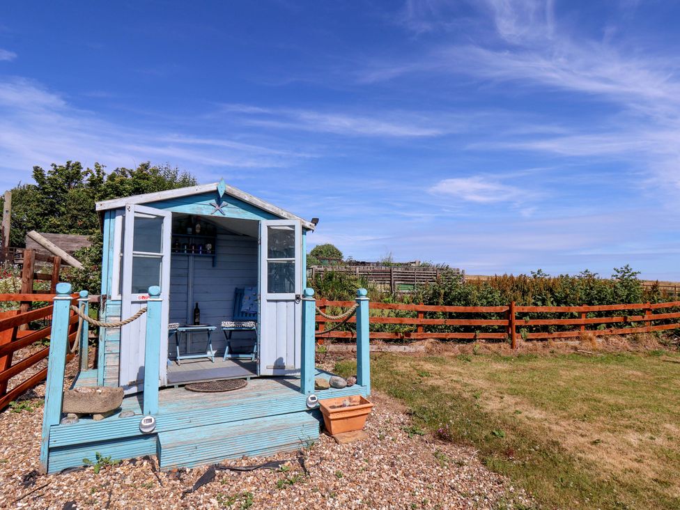 A garden shed with chairs on the decking at 4 Cliff Cottages Port Mulgrave near Staithes
