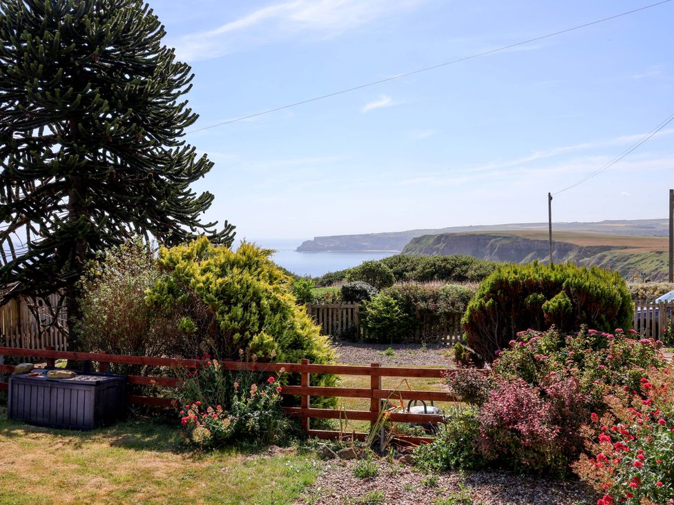 A garden view overlooking the ocean and hills at 4 Cliff Cottages in Port Mulgrave near Staithes