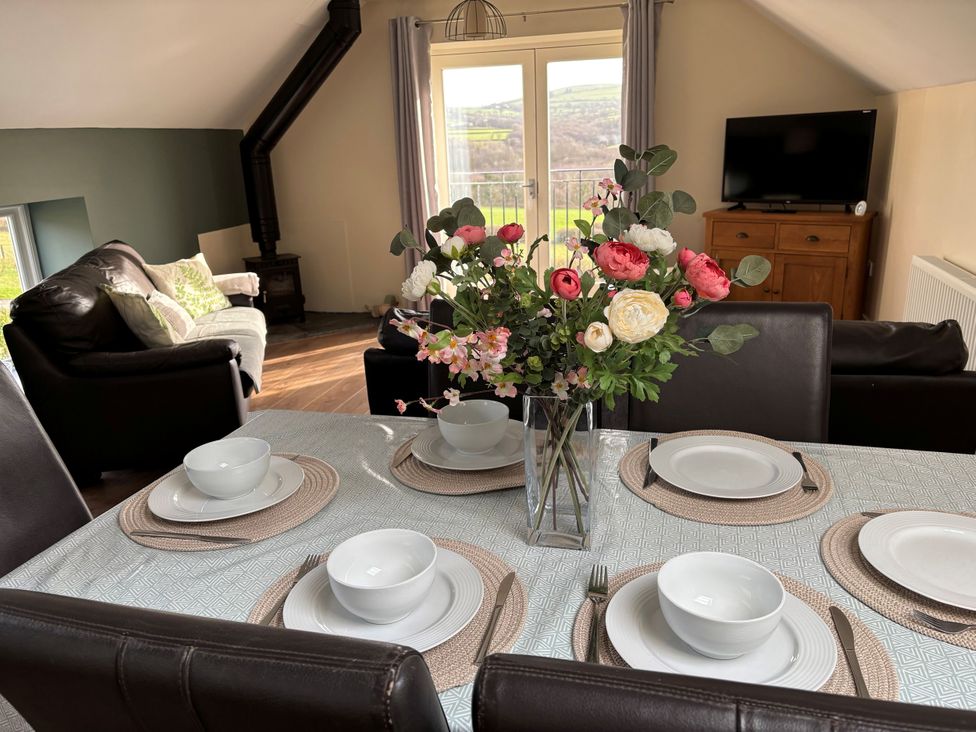A dining table with bowls set for a meal at Ysgubor - The Barn in Boncath near Crymych