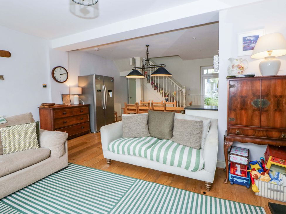A living room with a sofa and dining area at Rose Cottage in St Dogmaels near Cardigan