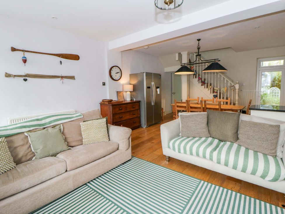 A living room with a sofa and dining area at Rose Cottage in St Dogmaels near Cardigan