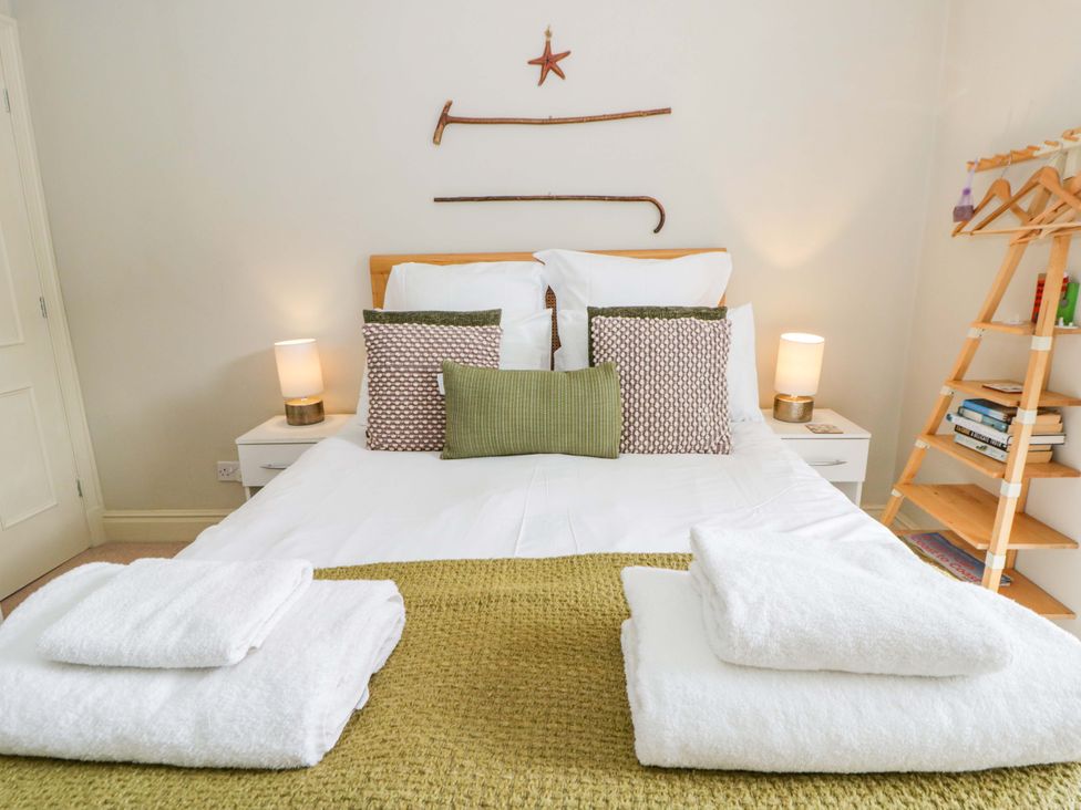 A bedroom with a bed and bedside table at Rose Cottage St Dogmaels near Cardigan