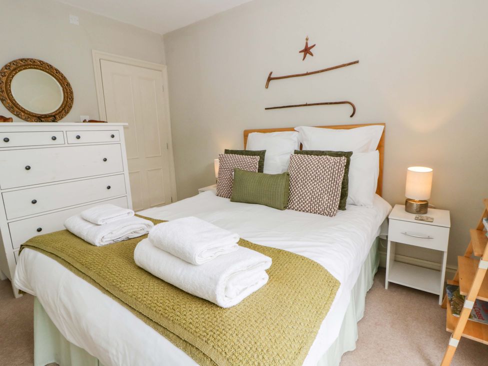 A bedroom with a bed and dresser at Rose Cottage St Dogmaels near Cardigan