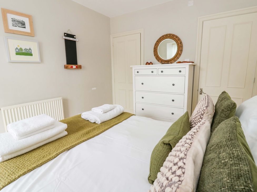 A bedroom with bed and dresser at Rose Cottage in St Dogmaels near Cardigan