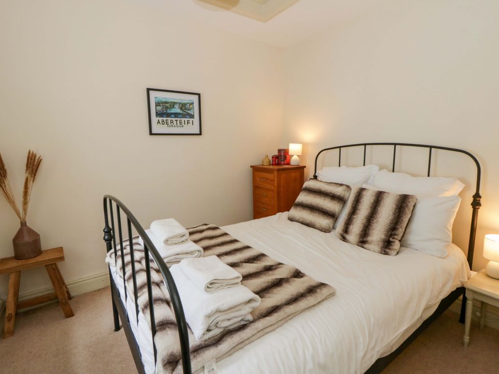 A bedroom with a bed and bedside tables at Rose Cottage St Dogmaels near Cardigan