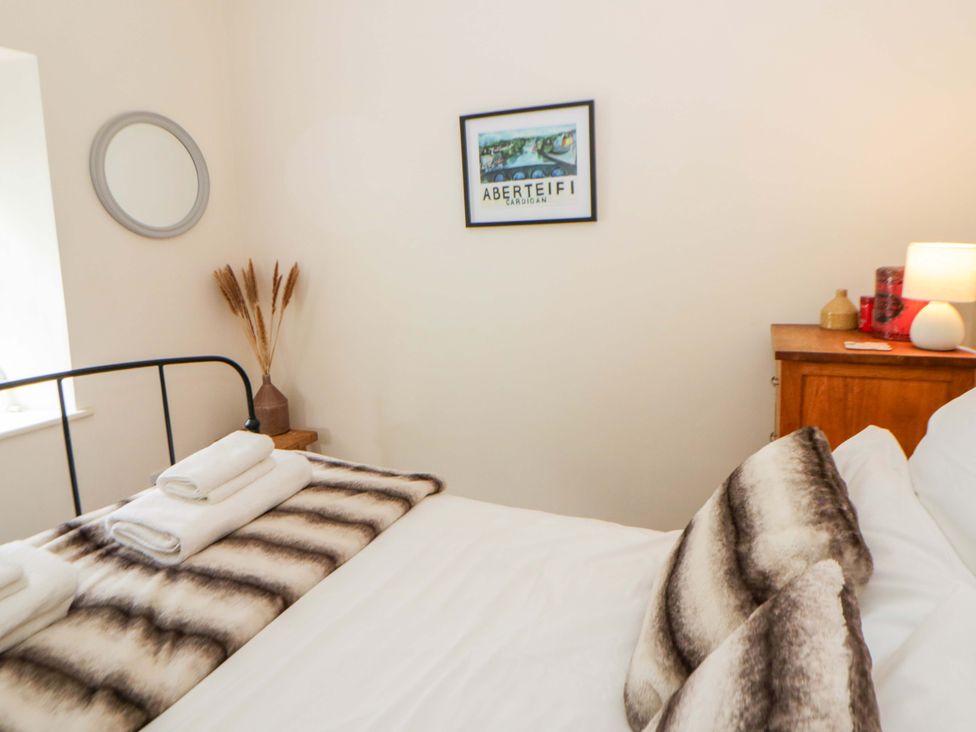 A bedroom with a bed and pillows at Rose Cottage St Dogmaels near Cardigan