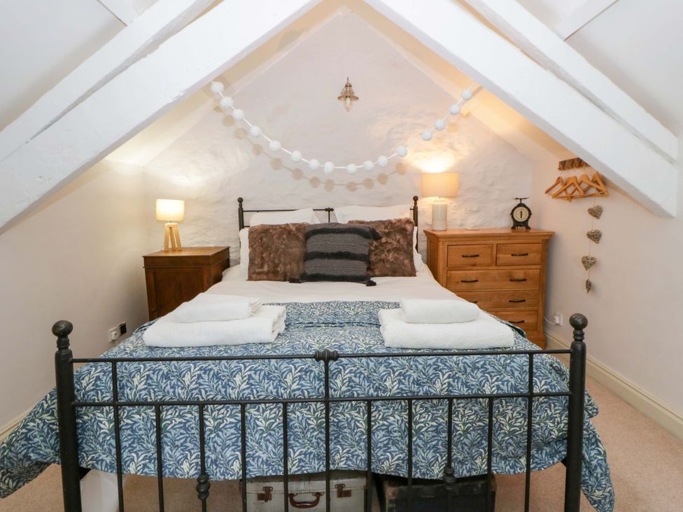 A bedroom with a bed and dresser at Rose Cottage St Dogmaels near Cardigan