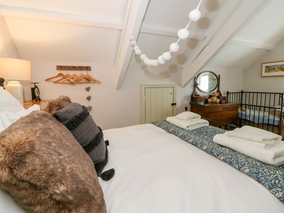 A bedroom with a bed and dresser at Rose Cottage St Dogmaels near Cardigan