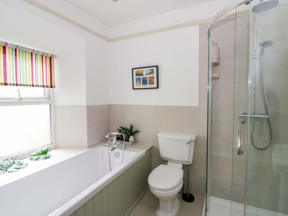 A bathroom with a bathtub, shower, and toilet at Rose Cottage in St Dogmaels near Cardigan