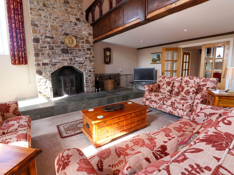 A living room with a fireplace and sofas at The Old Chapel in Clovelly