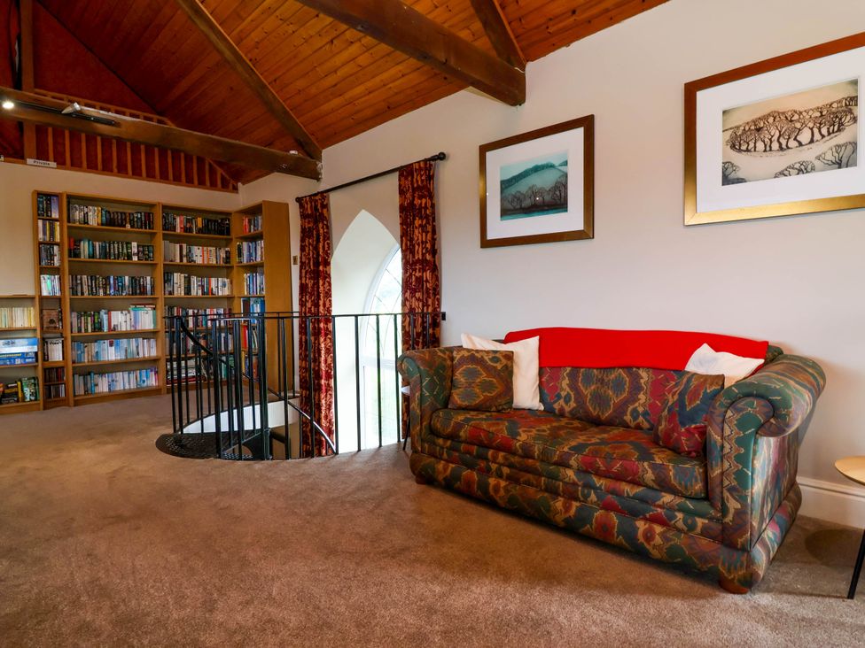 A reading area with a sofa and bookshelves at The Old Chapel in Clovelly