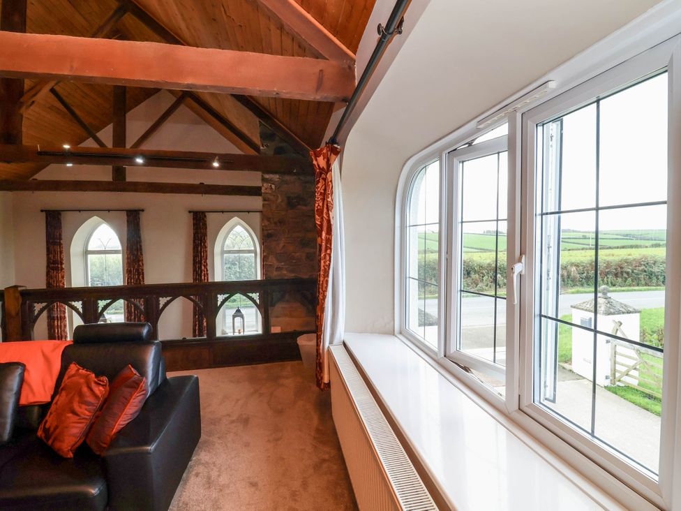 A living room with windows and a sofa at The Old Chapel in Clovelly
