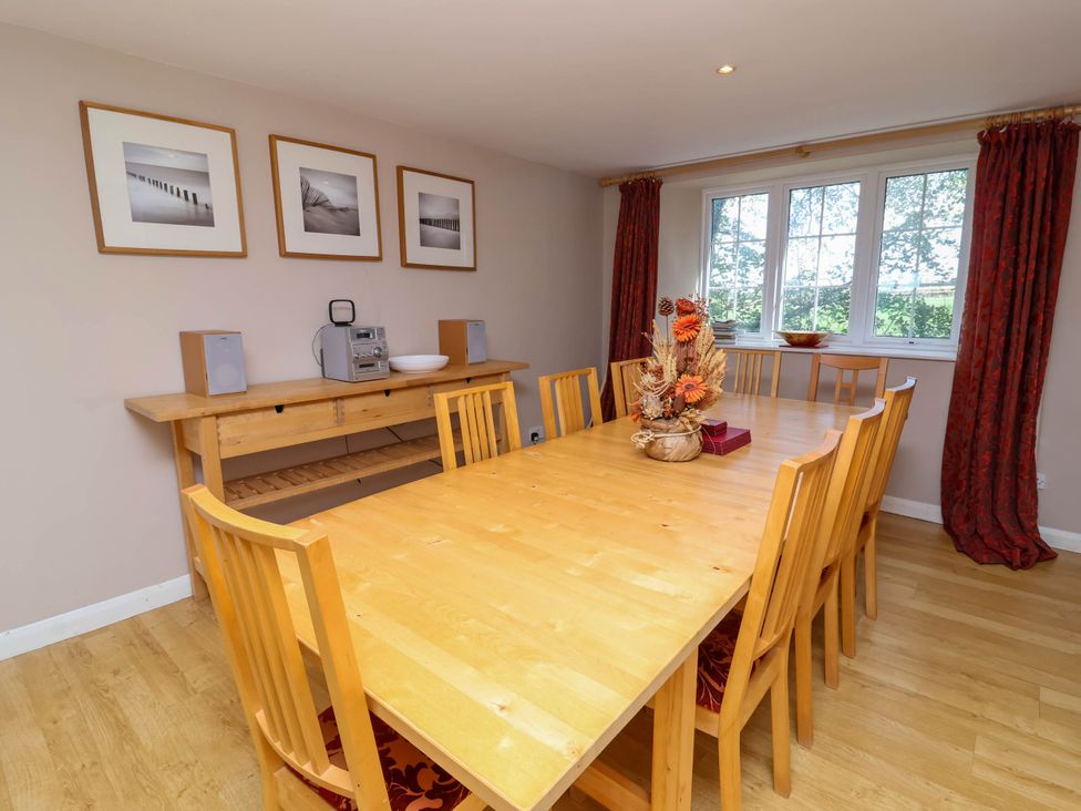 A dining room with a large table and decorative vase at The Old Chapel in Clovelly