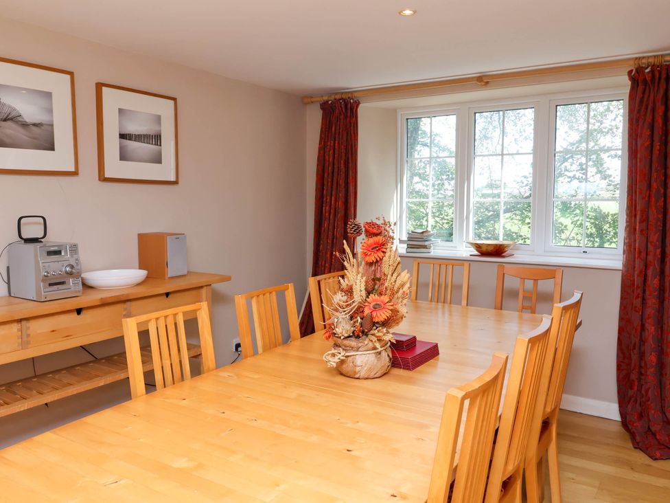 A dining room with a wooden table and chairs at Old Chapel in Clovelly