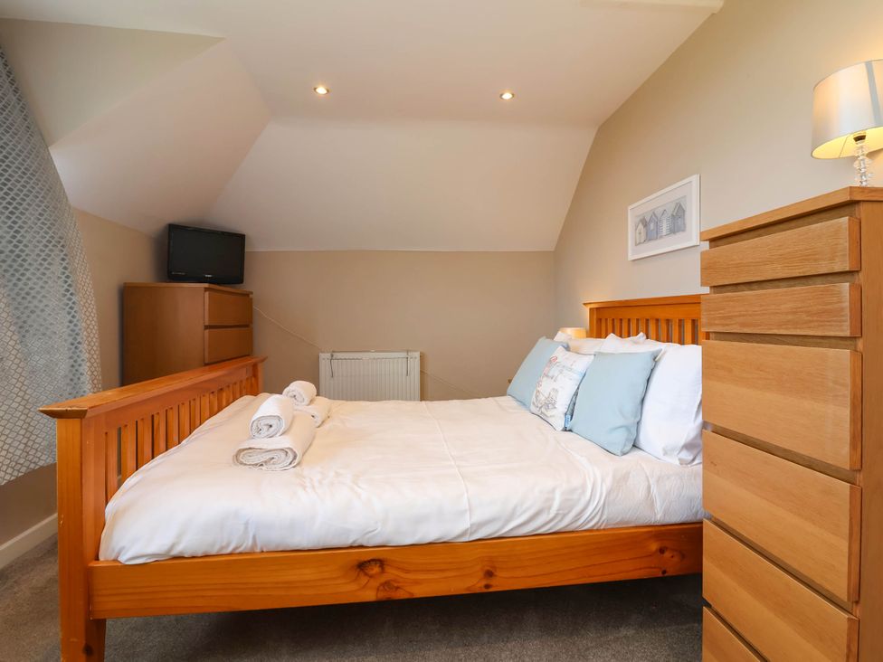 A bedroom with a bed and television at The Old Chapel in Clovelly