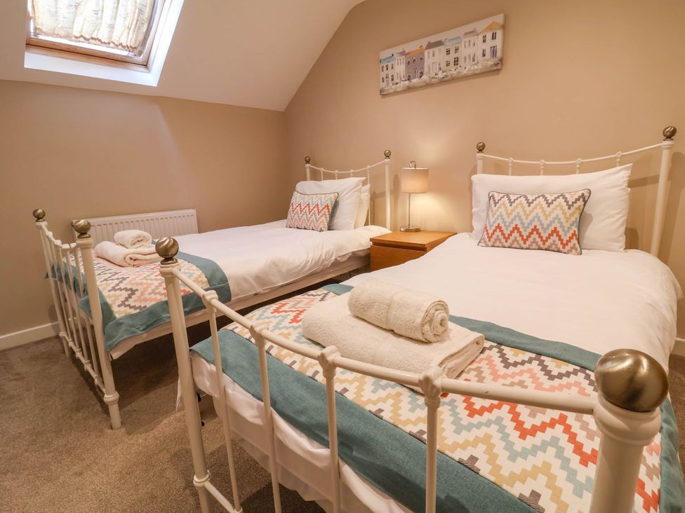 A bedroom with two beds and a lamp at Old Chapel in Clovelly