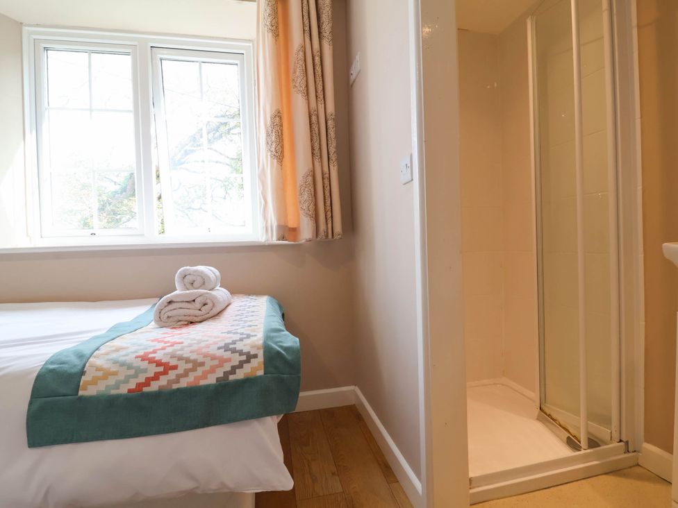 A bedroom with a bed and shower at The Old Chapel in Clovelly