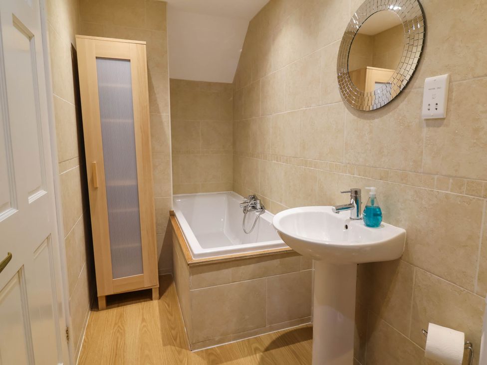 A bathroom with a bath tub and sink at Old Chapel in Clovelly