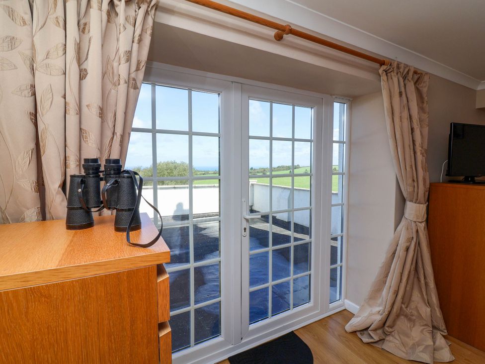 A room with binoculars on a dresser and a door leading outside at Old Chapel in Clovelly