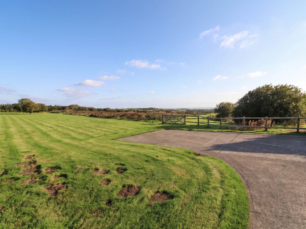 A lawn with a paved area and a gate at Old Chapel in Clovelly