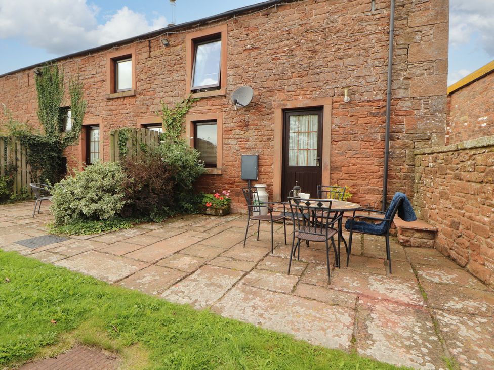 An outdoor patio area with a table and chairs at Stable Cottage Bolton Low Houses