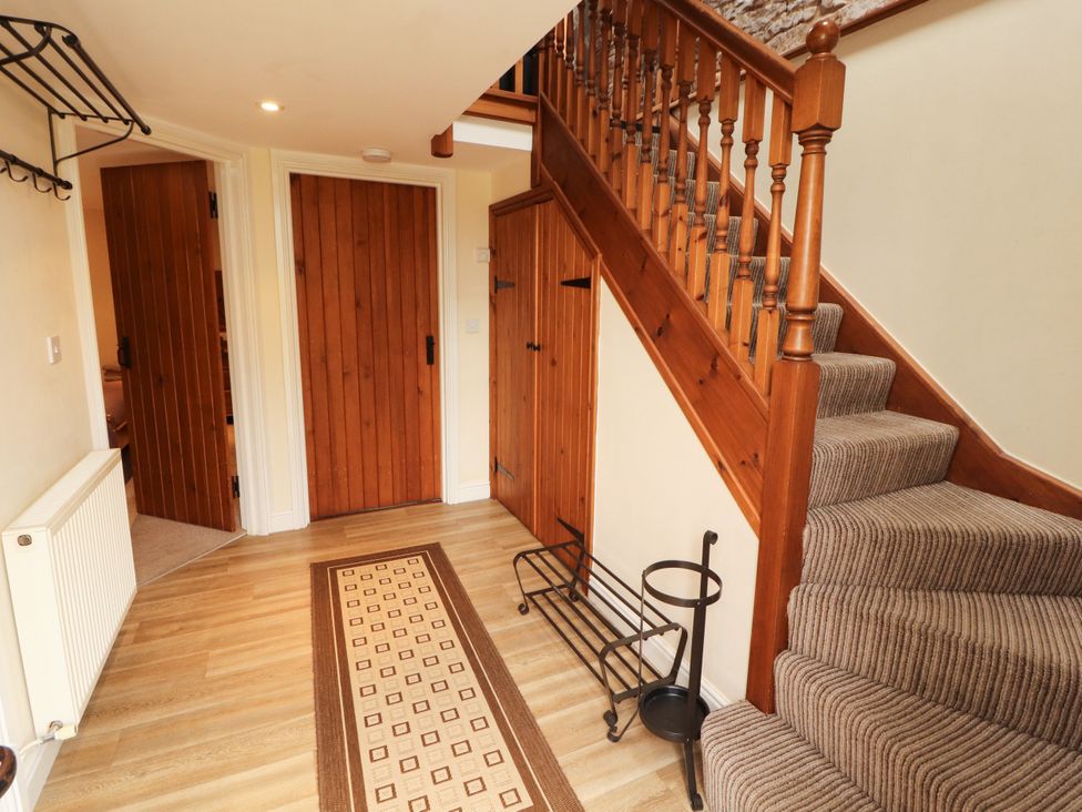 A hallway with a staircase and doors at Stable Cottage in Bolton Low Houses