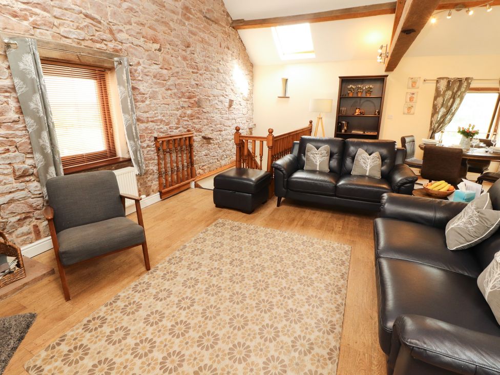A living room with sofas and a staircase at Stable Cottage in Bolton Low Houses