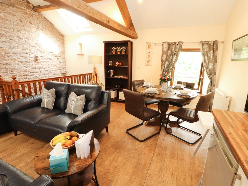 A living room with a dining table and sofa at Stable Cottage in Bolton Low Houses