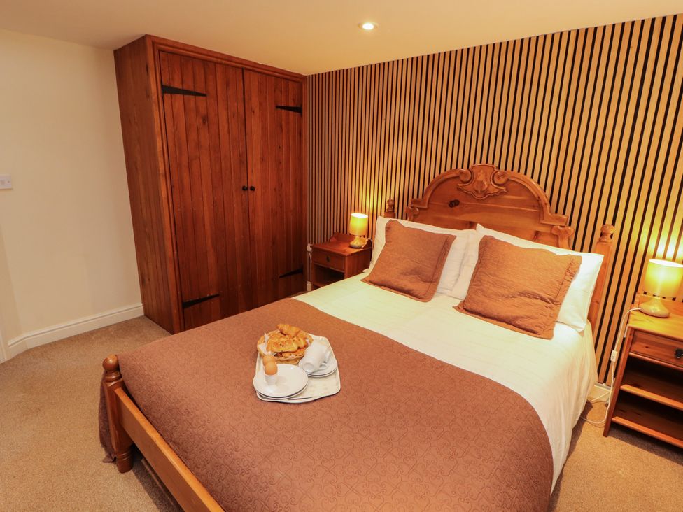 A bedroom with a bed and wardrobe at Stable Cottage Bolton Low Houses