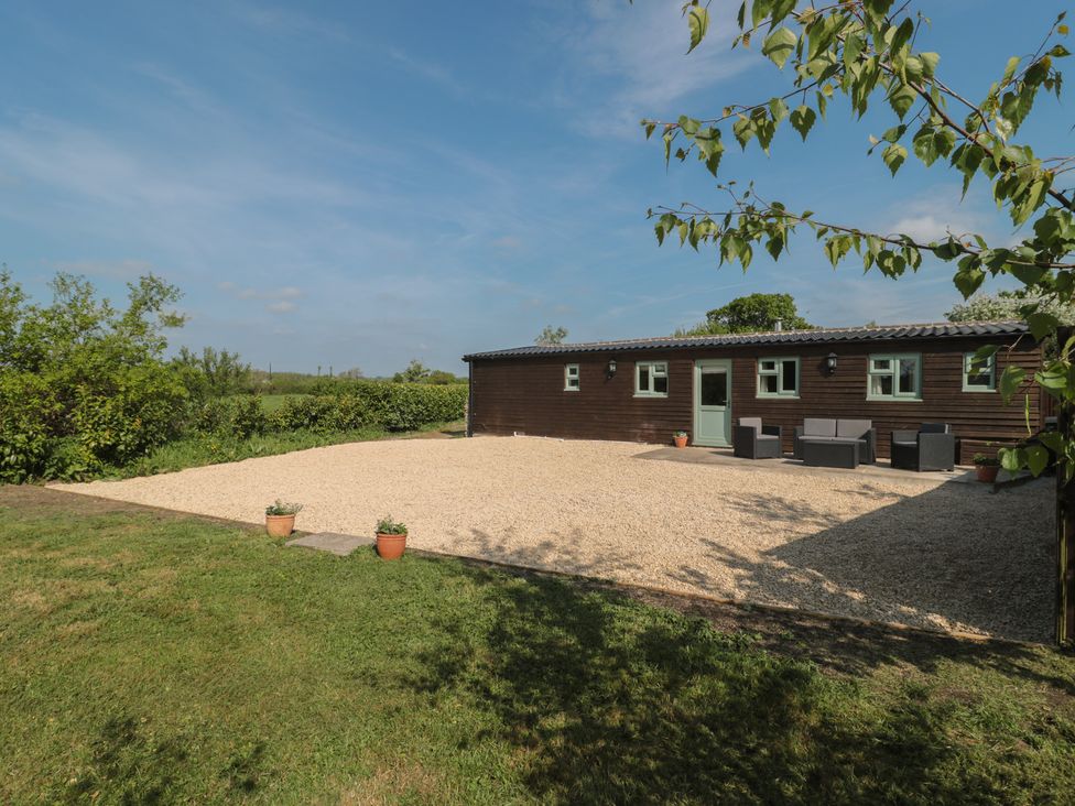 A garden with a gravel area and seating arrangement at Garden Cottage, Rode Farm in Rode