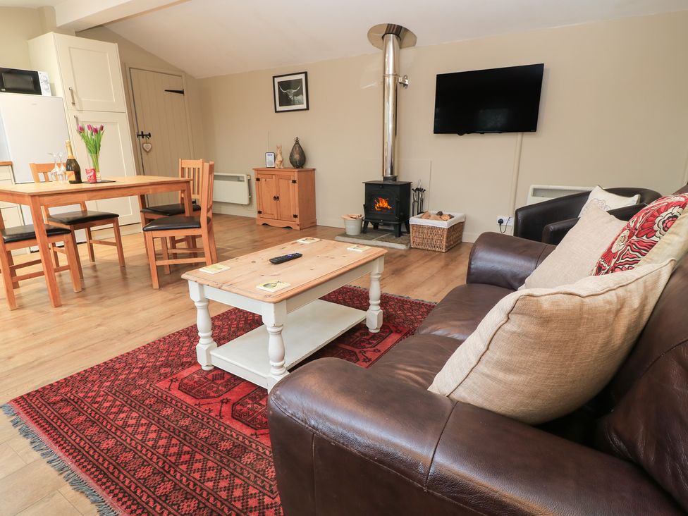 A living room with a fireplace and television at Garden Cottage, Rode Farm in Rode