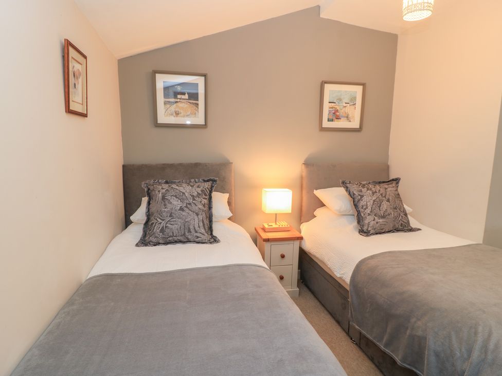 A bedroom with two single beds and a lamp at Garden Cottage, Rode Farm Rode