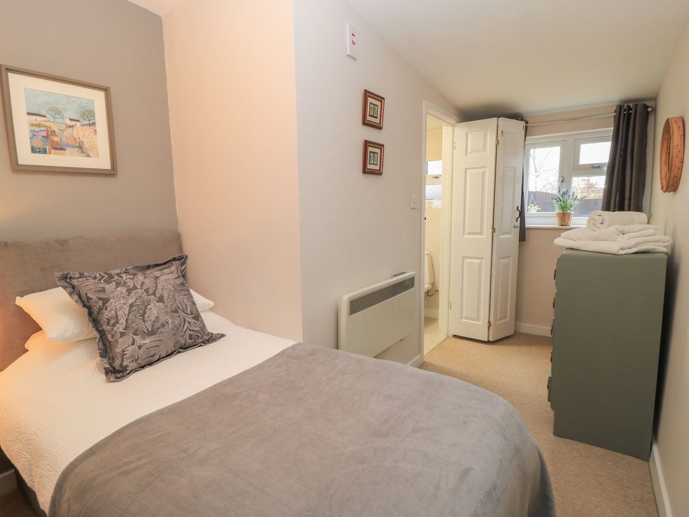 A bedroom with a bed and wardrobe at Garden Cottage, Rode Farm in Rode