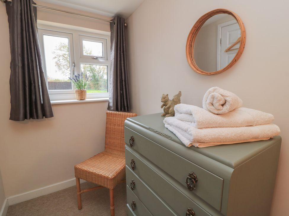 A bathroom with a window, towels, and a dresser at Garden Cottage, Rode Farm, Rode
