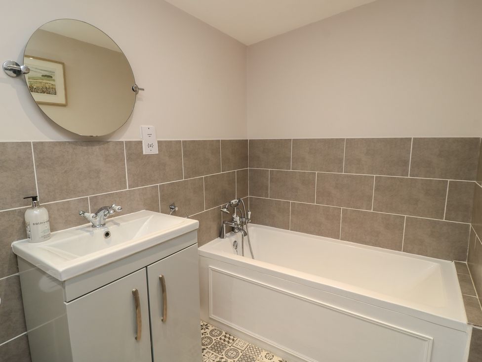 A bathroom with a bathtub and sink at Garden Cottage, Rode Farm in Rode