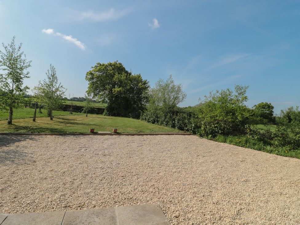 A garden area with gravel, grass, and trees at Garden Cottage, Rode Farm in Rode