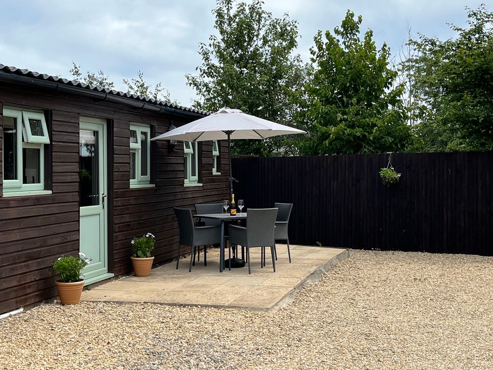 An outdoor seating area with a table and chairs at Garden Cottage, Rode Farm Rode